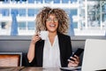 Happy hispanic afro business woman wearing eye glasses in cafe working on laptop, mobile phone Royalty Free Stock Photo