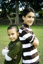 Happy hispanic brothers together in front of tree Royalty Free Stock Photo