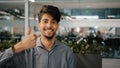 Happy hispanic employee arab man leader winner approve looking at camera showing thumb up agreement sign everything fine