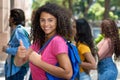 Happy hispanic female university student with group of caucasian and african american young adults Royalty Free Stock Photo