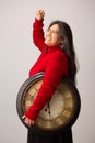 Happy Hispanic Woman With Clock Under Arm Lifts Fist In Triumph