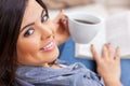 Happy Hispanic Woman Reading Book at Home and Drinking Tea or Coffee Royalty Free Stock Photo