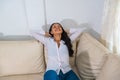 Happy hispanic woman resting comfortably sitting on a couch in the living room at home Royalty Free Stock Photo
