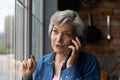 Happy hispanic woman retiree engaged in pleasant talk on phone