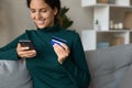 Happy hispanic woman using cell bank card for paying online Royalty Free Stock Photo