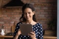 Happy Hispanic woman using computer tablet at home Royalty Free Stock Photo