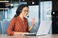 Happy hispanic woman working inside office, businesswoman with video call headset talking and advising customers Royalty Free Stock Photo