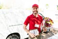 Smiling latin delivery courier working for a flower shop Royalty Free Stock Photo