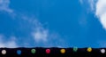 Happy holiday, event celebration background concept: line of colorful light bulbs on the roof eaves looking up, blue sky and white Royalty Free Stock Photo