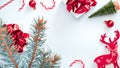 Happy holiday scene. White gift box with red ribbon, New Year balls and winter tree in Christmas composition on white background Royalty Free Stock Photo