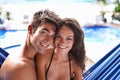 Happy holiday snap. Portrait of an affectionate young couple sitting in a hammock in swimwear. Royalty Free Stock Photo