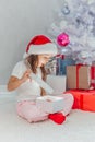 Happy holidays Cute little child opening present near Christmas tree. The girl laughing and enjoying the gift. Royalty Free Stock Photo