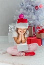 Happy holidays Cute little child opening present near Christmas tree. The girl laughing and enjoying the gift. Royalty Free Stock Photo