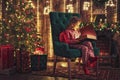 Happy holidays. Cute little child opening present near Christmas tree. The girl laughing and enjoying the gift. Royalty Free Stock Photo