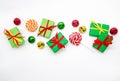 Happy holidays: gifts with lollipops and red, green, golden bells on a white background, copy space. The concept of Christmas, Royalty Free Stock Photo