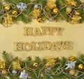 Happy holidays golden text and spruce branch and Christmas decor Royalty Free Stock Photo