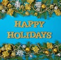 Happy holidays golden text and spruce branch and Christmas decor Royalty Free Stock Photo