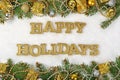 Happy holidays golden text and spruce branch and Christmas decor Royalty Free Stock Photo