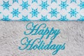 Happy Holidays greeting with snowflakes on gray plush material