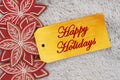 Happy Holidays greeting on a gift tag with wood poinsettias Royalty Free Stock Photo