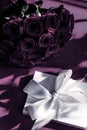 Luxury holiday silk gift box and bouquet of roses on purple background, romantic surprise and flowers as birthday or Valentines