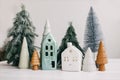 Happy holidays. Miniature cozy village, ceramic houses, wooden and handmade christmas trees. Christmas little houses and trees on