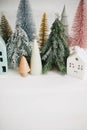 Happy holidays. Miniature cozy village, ceramic houses, wooden and handmade christmas trees. Christmas little houses and trees on