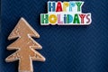 Happy Holidays plaque message and a glitter gingerbread Christmas Tree on blue background Royalty Free Stock Photo