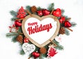 Happy Holidays Text with Holiday Evergreen Branches, frame in the shape of a heart Royalty Free Stock Photo