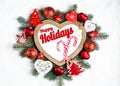 Happy Holidays Text with Holiday Evergreen Branches, frame in the shape of a heart Royalty Free Stock Photo
