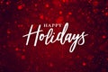 Happy Holidays Text Over Festive Red Sparkle Glitter Background. Magical Christmas Calligraphy Font with Glowing Bokeh Lights. Royalty Free Stock Photo