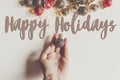 Happy holidays text, seasonal greetings card sign. hand holding Royalty Free Stock Photo