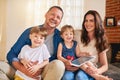 The happy home is made with a familys love. Portrait of a happy young family of four relaxing together on the sofa at Royalty Free Stock Photo