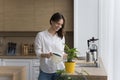 Happy homeowner girl growing, watering potted plant at home Royalty Free Stock Photo