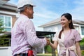 Happy homeowner stand in front of contractor and shake hand, handyman holding clipboard and after checking details before Royalty Free Stock Photo