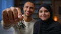 Happy homeowners african american arabian muslim multiracial diversity couple showing keys from new home real estate Royalty Free Stock Photo