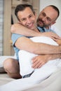 happy homosexual couple cuddling sitting on bed Royalty Free Stock Photo