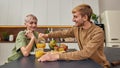 Happy homosexual couple pouring juice into glass Royalty Free Stock Photo