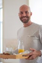 Happy homosexual man bringing his partner breakfast in bed Royalty Free Stock Photo