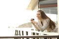 Happy hotel guest holding coffee looking at you