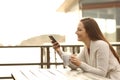 Happy hotel guest using a smart phone outdoors