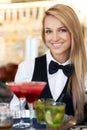 Happy hour. Portrait of a beautiful barmaid serving cocktails at a barrestaurant.