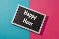 Happy hour - text on chalkboard on blue and pink