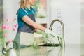 Happy housekeeper washes a plate