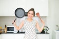 Happy housewife hold up with pan wooden turner in kitchen Royalty Free Stock Photo