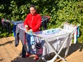 happy housewife holding the wet clothes just removed from the washing machine in the washing line put on the terrace of a garden Royalty Free Stock Photo