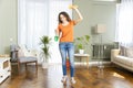 Happy housewife makes house cleaning holding rag spray bottle detergent Royalty Free Stock Photo