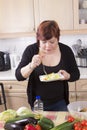 Happy housewife tasting vegetable salad