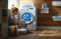 Happy housewife woman in laundry room with washing machine Royalty Free Stock Photo