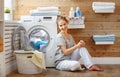 Happy housewife woman in laundry room with washing machine Royalty Free Stock Photo